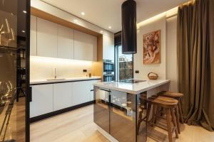 a kitchen with white cabinets and a bar with a stool at Sael Privè in Golem