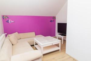 a living room with a white couch and a purple wall at Hostel Fjordur in Hafnarfjörður
