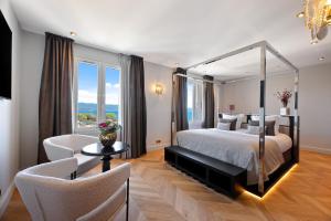 a bedroom with a large bed and a living room at Hotel San Carlu Citadelle Ajaccio in Ajaccio