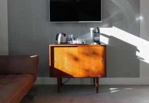 a wooden cabinet with a television on top of it at Boutique Hotel Nieuw Uilenburg in Den Bosch