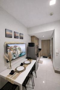 a kitchen with a table and a tv on the wall at Casa MJ Suites at SMDC Fame Residences, Mandaluyong in Manila