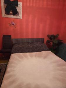a bedroom with a bed and a red wall at Apartament Wiejska 5a in Ciechocinek +9 photos
