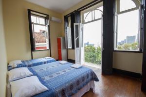 1 Schlafzimmer mit 2 Betten und einem großen Fenster in der Unterkunft Rio Forest Hostel in Rio de Janeiro