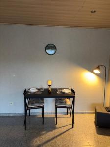 ein Tisch mit zwei Stühlen und eine Uhr an der Wand in der Unterkunft Tiny Timeout in Braunschweig
