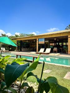 a villa with a swimming pool and a house at Pousada Rancho Luar in Pôrto de Pedras