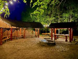 a pavilion with a fire pit next to a building at GAMP Paweł Sawicki in Kleszczele