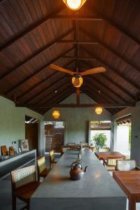 a dining room with a large table and a ceiling fan at The Yala Lodge in Kirinda