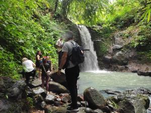 a group of people standing in front of a waterfall at Indra Yoga Retreat in Selemadeg