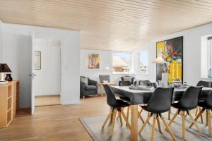 a dining room and living room with a table and chairs at 705-Thyboron-Romovej-7 in Thyborøn
