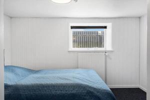 a bedroom with a blue bed and a window at 705-Thyboron-Romovej-7 in Thyborøn