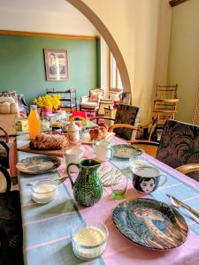 a table with plates and bowls on top of it at La Maison de Marie in Les Rouges-Eaux