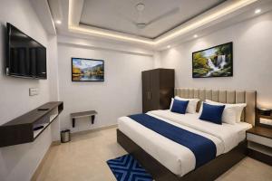 a bedroom with a large bed and a television at The Nest Kashi in Varanasi +10 photos