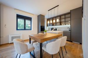 a kitchen with a wooden table and some chairs at Villa Azure Luxe in Škaljari