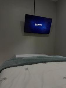 a bed with a tv on the wall above it at Divine2 Elegant Luxury suite in Bloemfontein