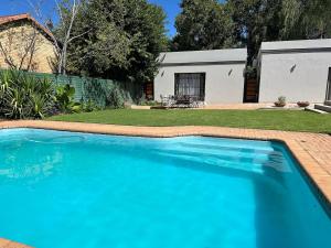 a large blue swimming pool in a yard at Divine2 Elegant Luxury suite in Bloemfontein