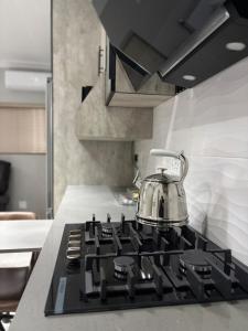 a tea kettle sitting on top of a stove in a kitchen at Divine2 Elegant Luxury suite in Bloemfontein