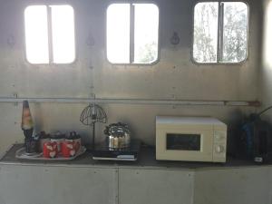 a microwave sitting on a counter in a kitchen at Retro caravan in Rock +24 photos