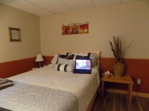 um quarto com uma cama com um computador portátil em Gîte Esprit Follet em Baie-Saint-Paul