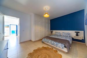 a bedroom with a bed and a blue wall at Luxury Suite Sea Front III in Playa Honda