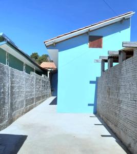 a wall with a blue door on a building at Casa simples e aconchegante em Poços de caldas in Poços de Caldas
