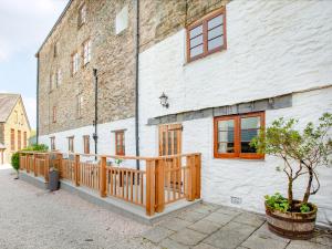 a white building with a wooden deck next to a building at Tuckenhay, 2 Castle Cottage - Fcl in Ashsprington +38 photos