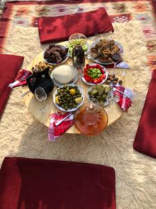 a table with plates of food and wine glasses on it at Mirjana Guesthouse in Pukë