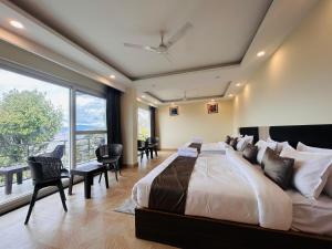 a bedroom with a large bed and a large window at The Hill Heaven A Luxury Property With Balcony & Mountain View Rooms in Mussoorie +141 photos