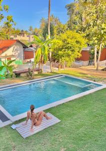 a woman in a bikini laying on a mat next to a swimming pool at MAYA Ahangama in Ahangama