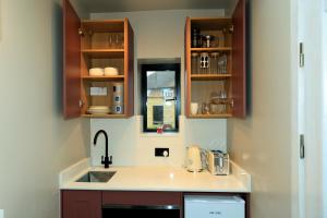 a kitchen with a sink and a counter top at Heathrow Royal Apartment in Ashford