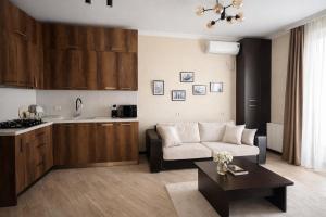a kitchen and a living room with a couch and a table at Home Inn Apartments Your house Jikia-Central Tbilisi in Tbilisi City