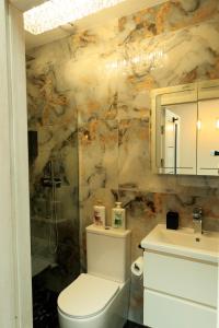 a bathroom with a toilet and a sink at Heathrow Royal Apartment in Ashford