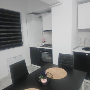 a kitchen with a black table and chairs and a stove at New studio in Râmnicu Vâlcea