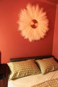 a bedroom with a bed with a red wall with a wreath at Heathrow Royal Apartment in Ashford