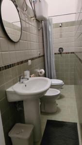 a bathroom with a sink and a toilet and a mirror at Camera doppia in San Giuseppe Vesuviano