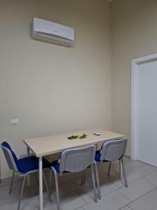 a table with four chairs and a air conditioner at Camera doppia in San Giuseppe Vesuviano