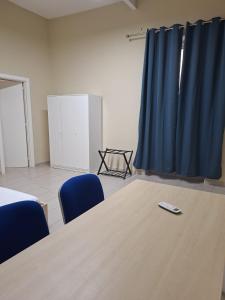 a conference room with a table and blue chairs at Camera doppia in San Giuseppe Vesuviano