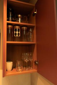 a cabinet with wine glasses and other dishes in it at Heathrow Royal Apartment in Ashford +14 photos