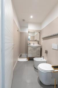 a white bathroom with a toilet and a sink at Foresteria SMART ROOMS in Viadana +26 photos