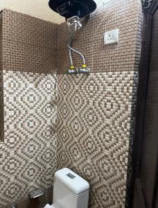 a bathroom with a toilet and a shower in it at Metro 21 in Faridabad