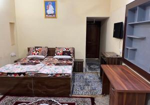 a room with a bed and a table and a tv at Metro 21 in Faridabad +8 photos