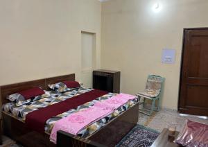 a bedroom with a large bed and a chair at Metro 21 in Faridabad