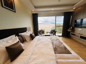 a large bed in a room with a large window at The Hill Heaven A Luxury Property With Balcony & Mountain View Rooms in Mussoorie