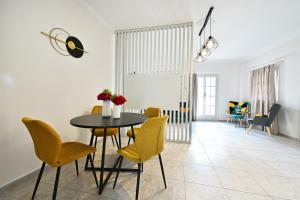a dining room with a table and yellow chairs at Mani Villa Ilias in Agios Nikolaos