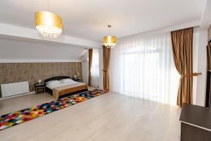 a bedroom with a bed and a large window at Pensiunea Axa Alex in Stăneşti