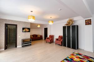 a living room with two chairs and a couch at Pensiunea Axa Alex in Stăneşti