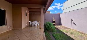 a patio with a table and chairs on a house at SOBRADO - ótimo custo beneficio - 3 quartos com ar in Campo Grande