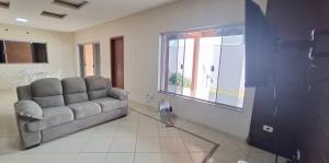 a living room with a couch and a window at SOBRADO - ótimo custo beneficio - 3 quartos com ar in Campo Grande