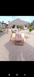 two chairs and an umbrella on a beach at Demba Dou Suites Gardens in Batukunku +20 photos