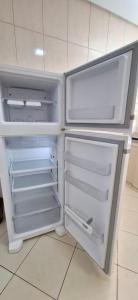 an empty refrigerator with its door open in a kitchen at SOBRADO - ótimo custo beneficio - 3 quartos com ar in Campo Grande