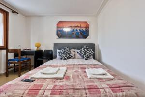 a bedroom with a large bed with two towels on it at Villa jolly mini appartament in Marghera